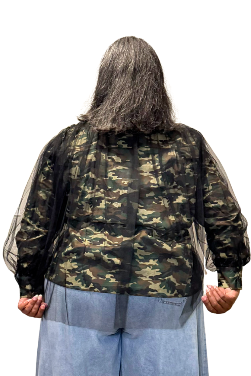 A person shown from the back wearing a camouflage top with sheer black mesh against a plain white background.